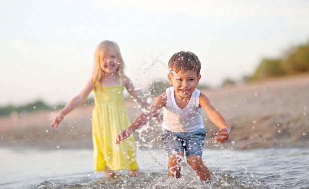 Girl and boy playing at the beach
